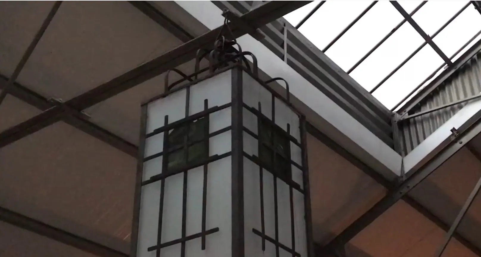 Dos faroles colgantes antiguos con detalles decorativos en un ambiente moderno.