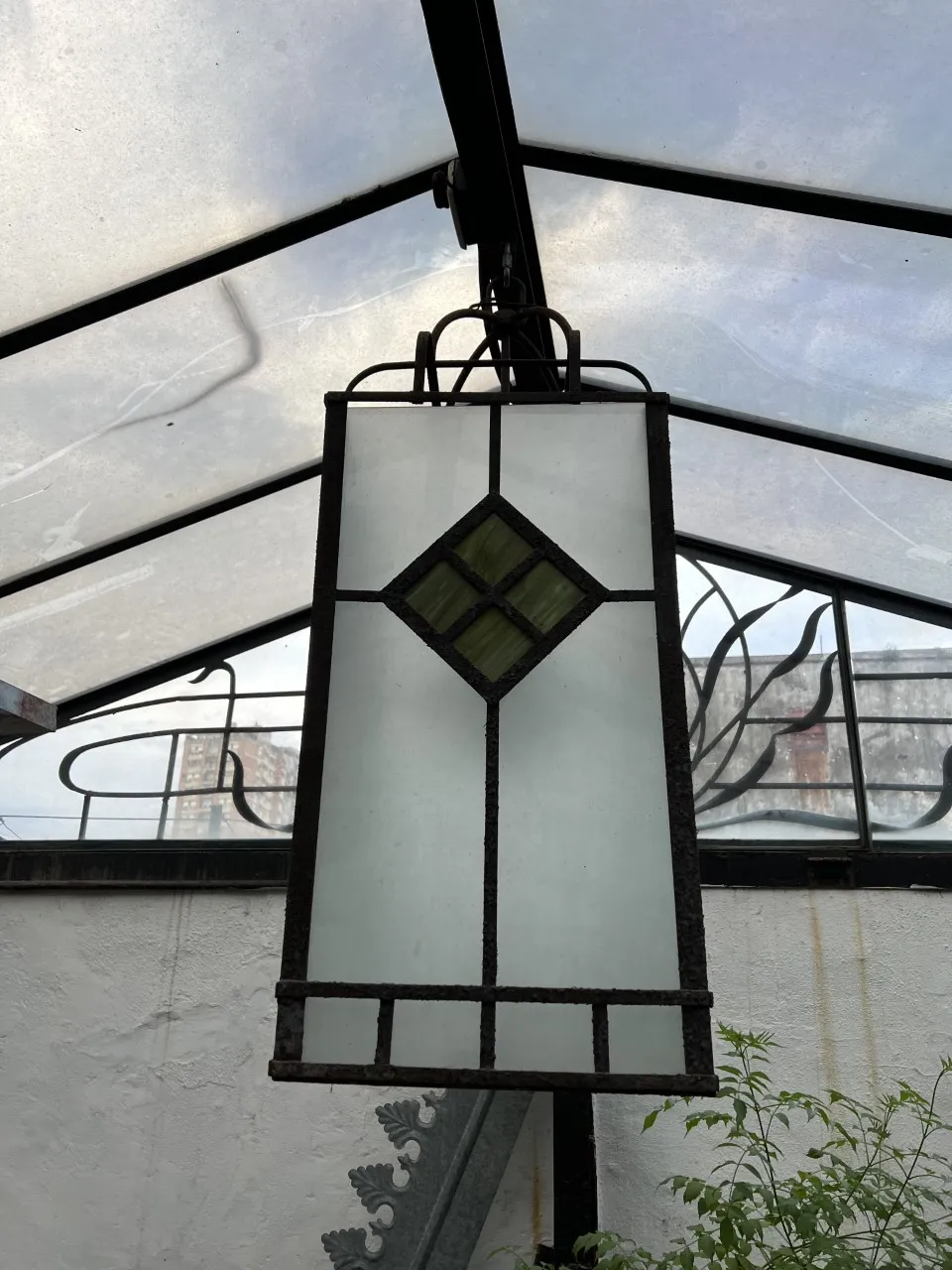 Deux lanternes suspendues anciennes avec un design en verre dépoli et vert.