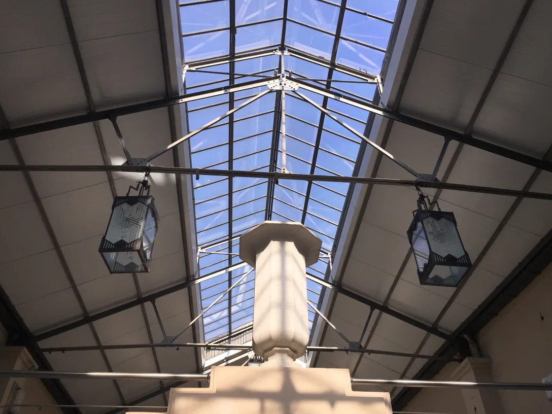 two antique lanterns hanging from a modern roof