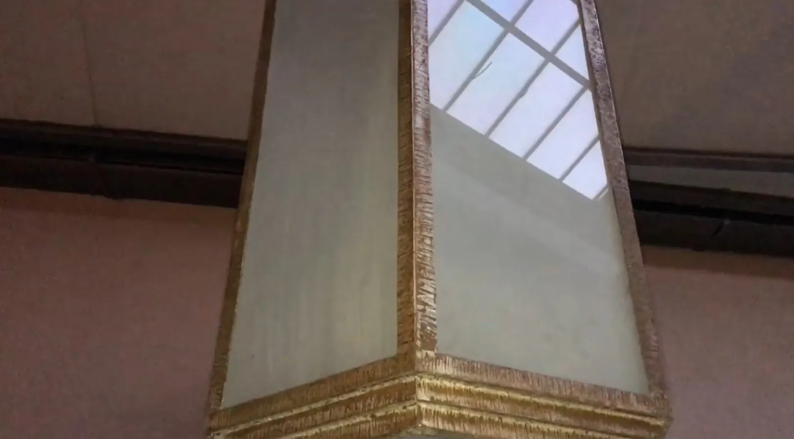 Dos faroles antiguos con marco dorado, ideales para interiores elegantes.