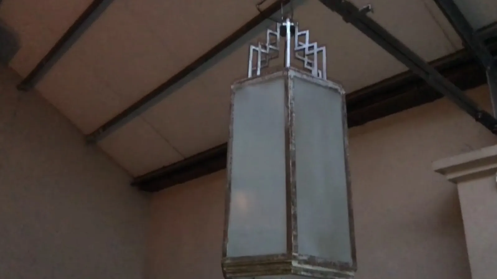 Deux lanternes anciennes suspendues avec un design unique dans un environnement accueillant.