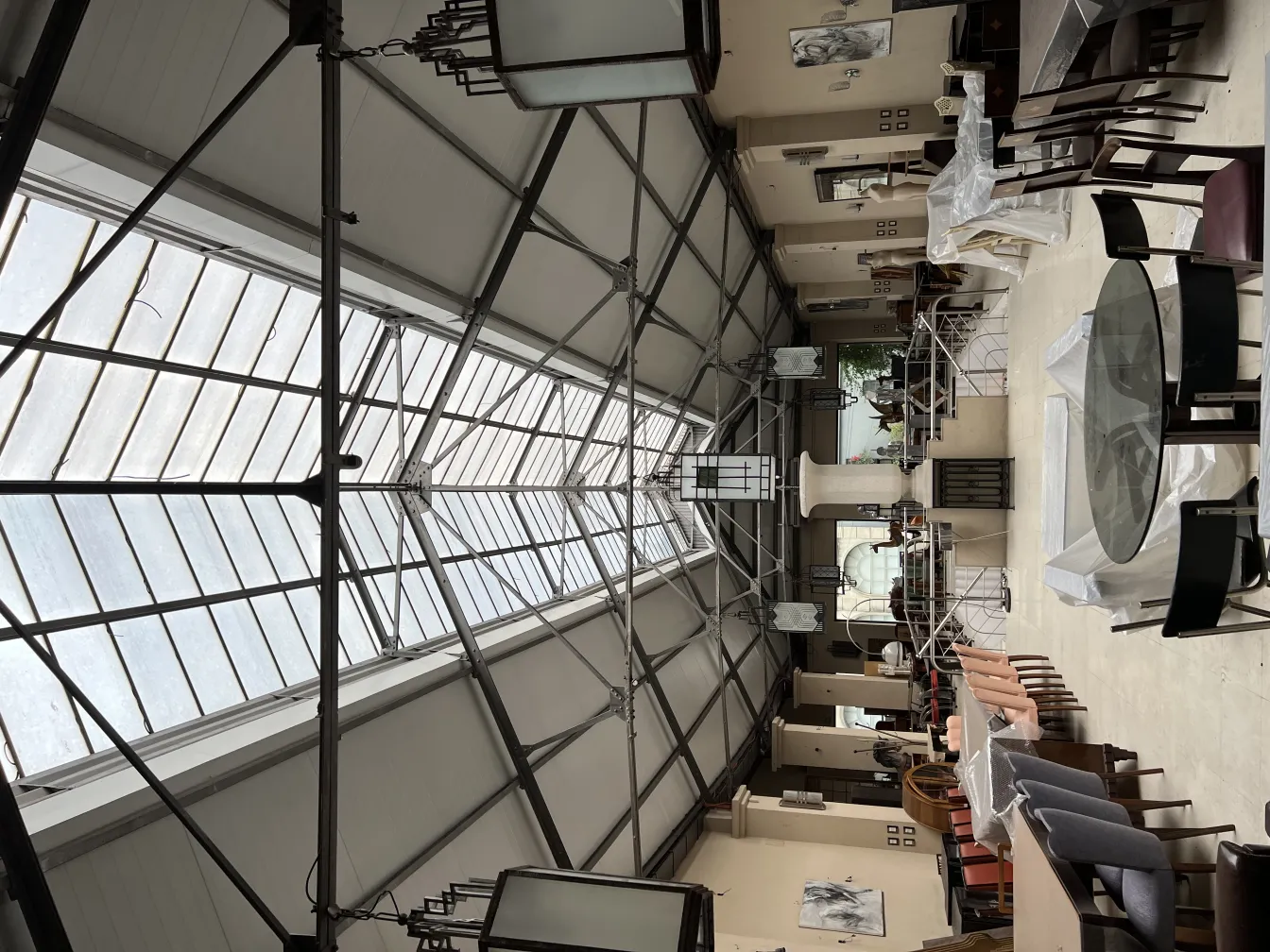 Deux lanternes anciennes suspendues dans un espace intérieur spacieux avec des tables et des chaises