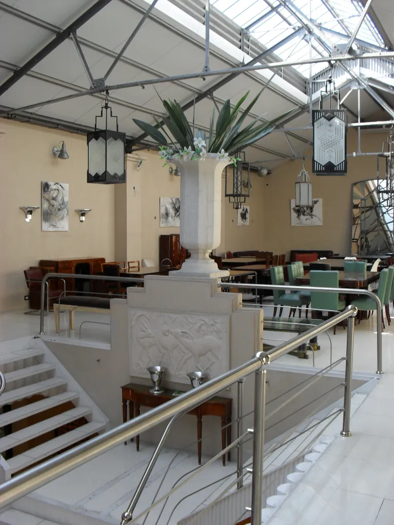 Deux lanternes anciennes suspendues dans un espace intérieur élégant avec des plantes.