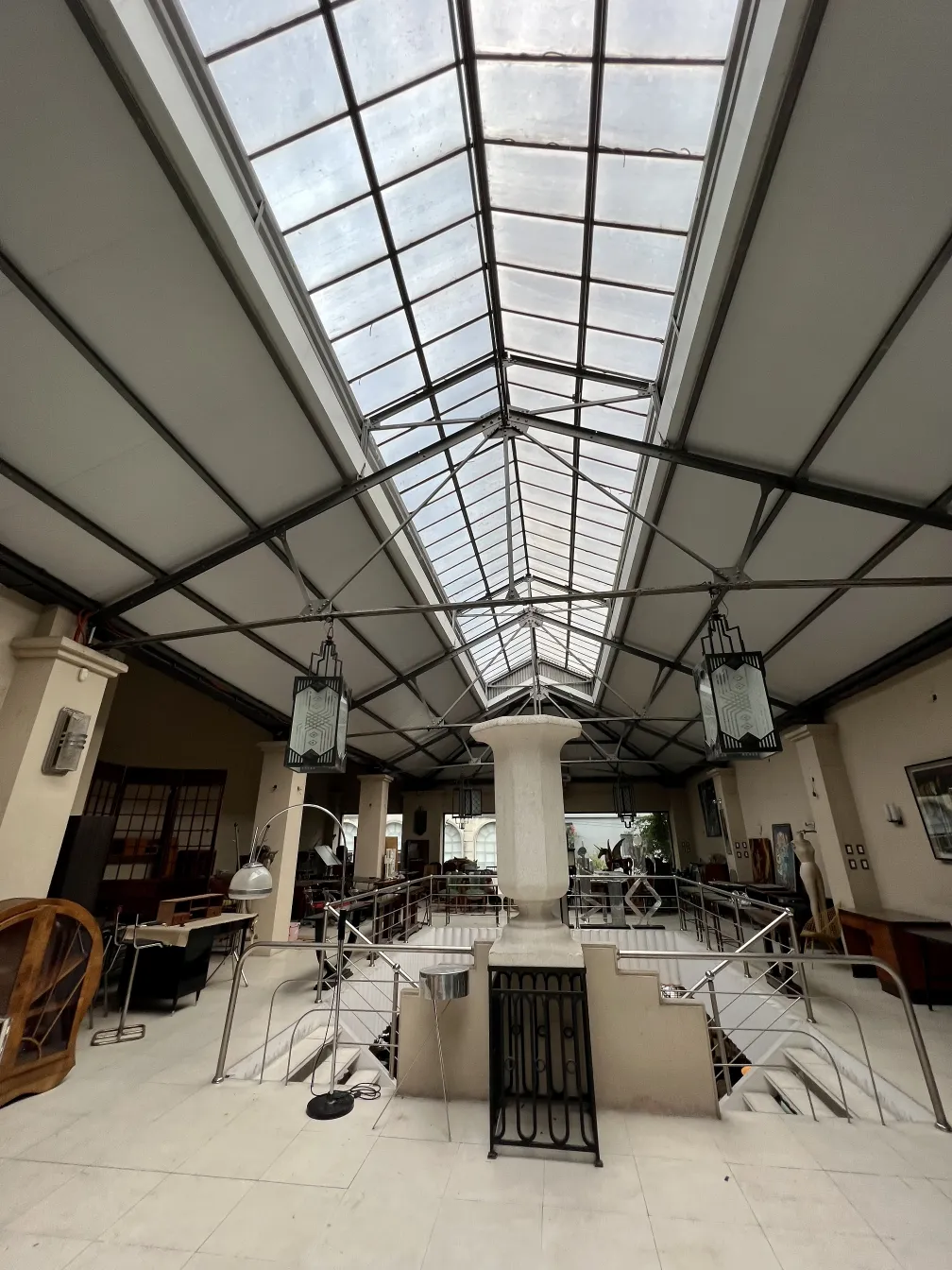 Dos faroles antiguos colgando en un ambiente interior amplio con arquitectura moderna