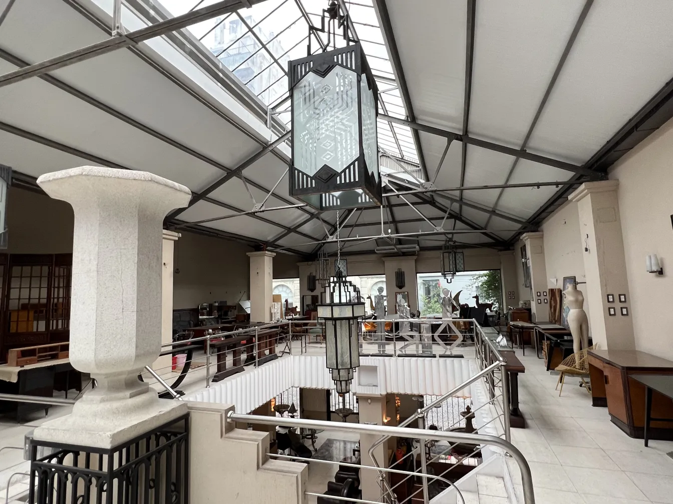 Deux lanternes anciennes décoratives suspendues dans un espace spacieux avec une rampe et une atmosphère vintage.