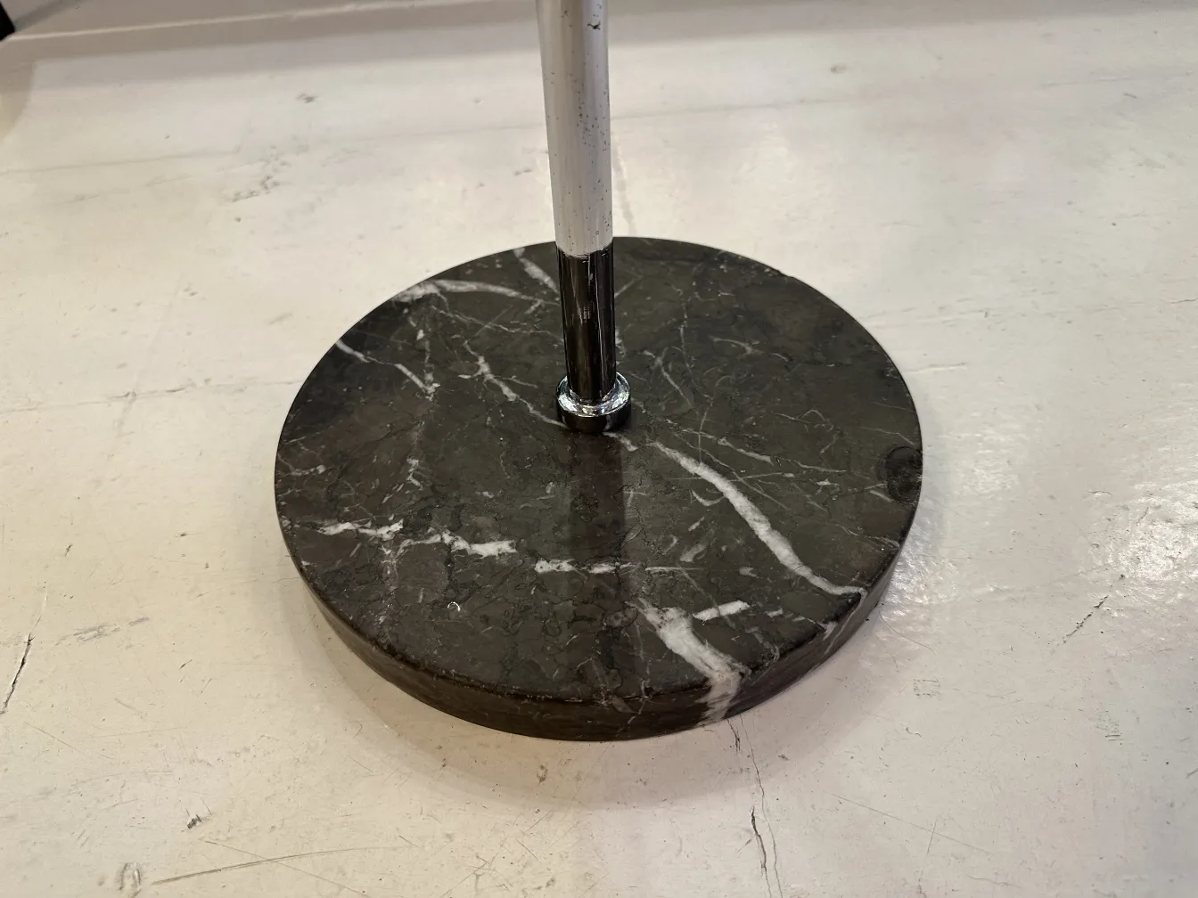 Antique champagne cooler with a round base and shiny metal support.