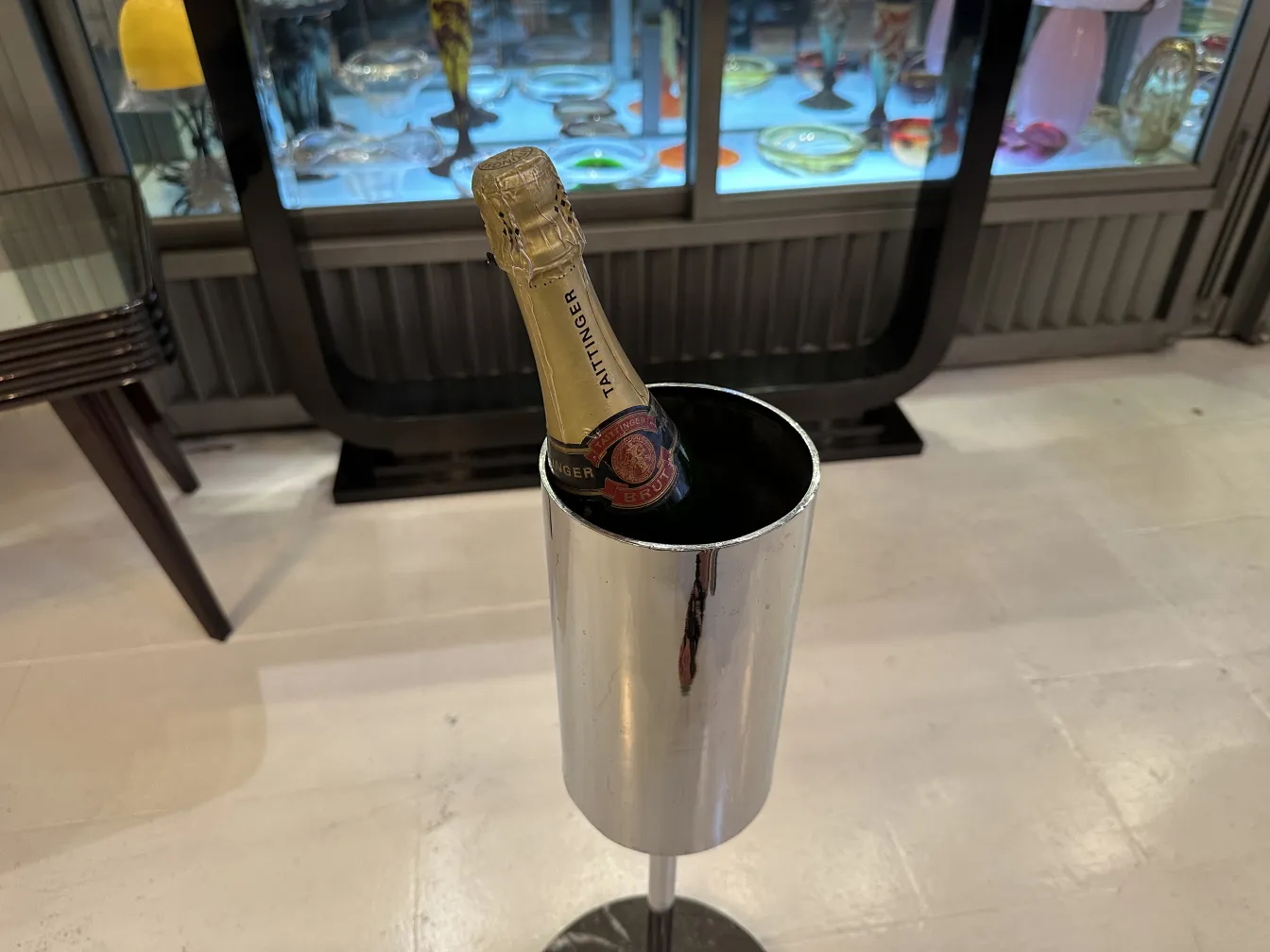 Secchiello per champagne antico con bottiglia in un ambiente elegante.
