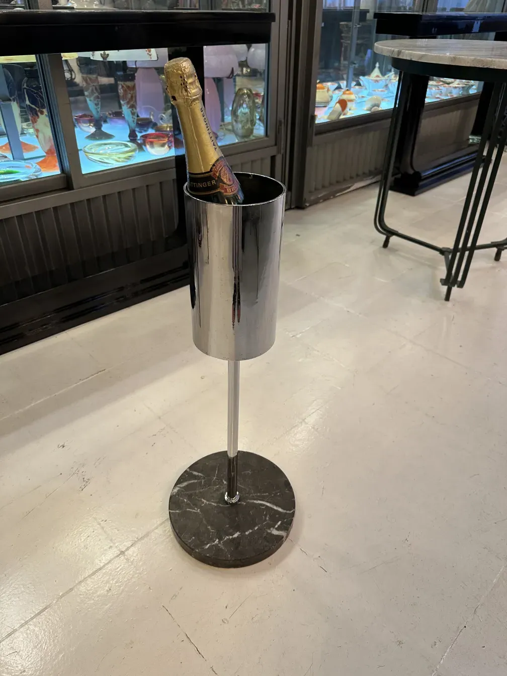 Champanera antigua brillante con base de mármol, elegante, en un ambiente acogedor