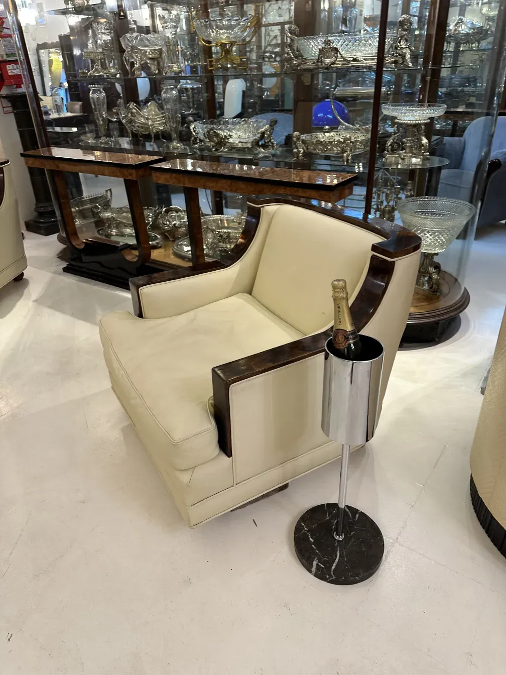 Champanera antigua con acabado brillante junto a una silla