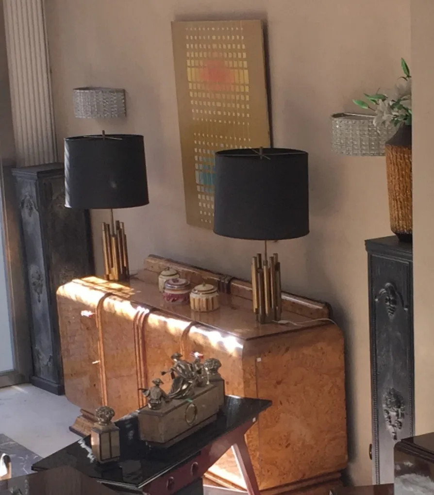 Vaisselier ancien avec lampes décoratives et art mural.