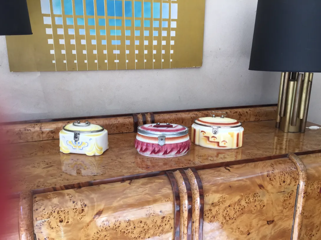 Aparador antiguo con accesorios de cerámica coloridos sobre la superficie.