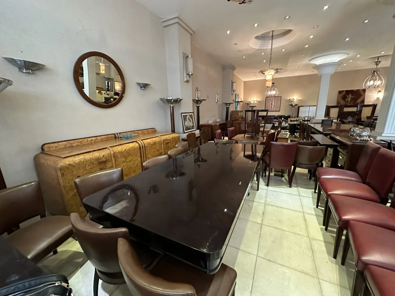 Credenza antica con finitura in legno, circondata da sedie in un ambiente elegante.