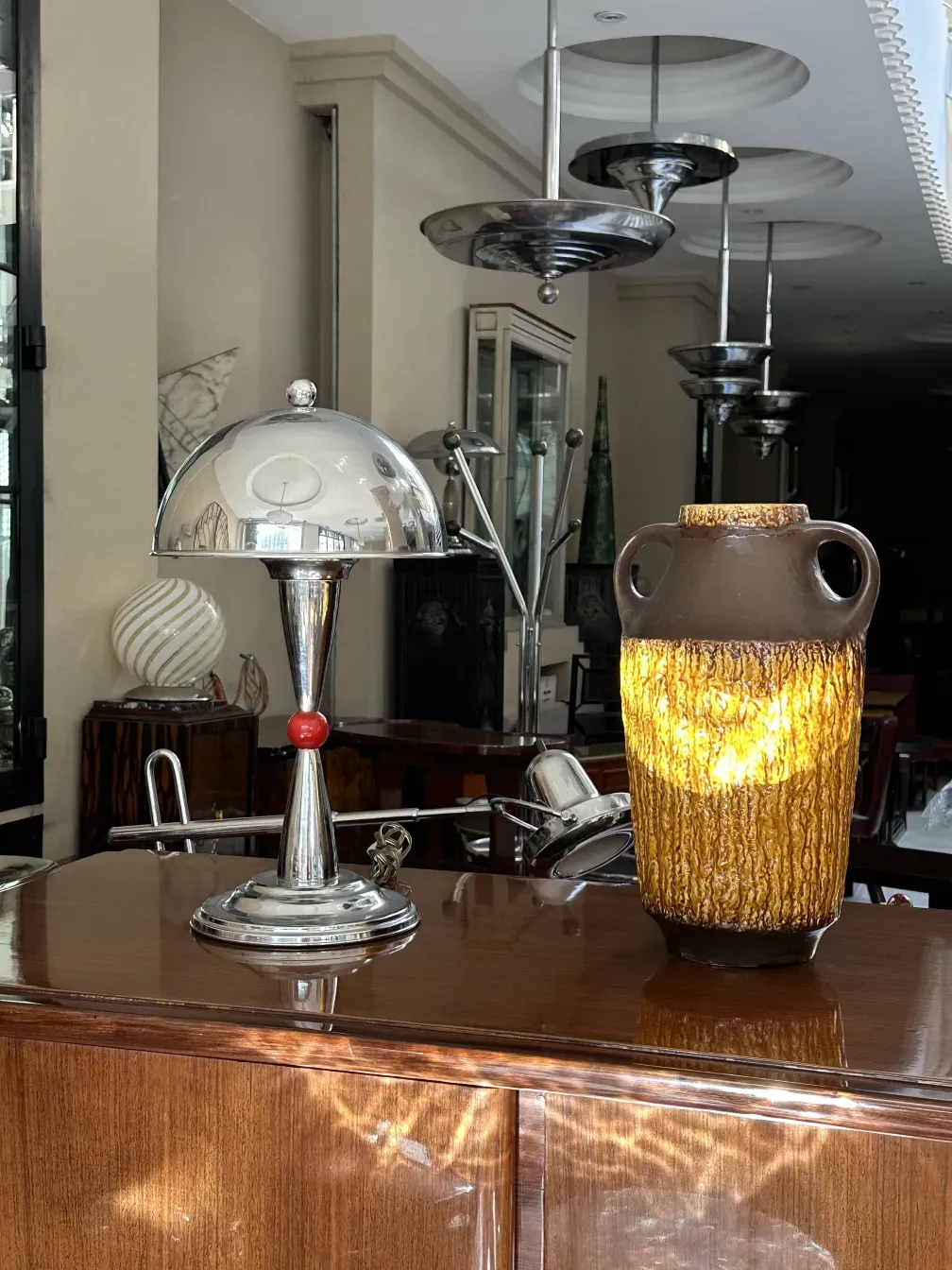 Credenza antica in legno con elementi decorativi, tavolo con accessori.