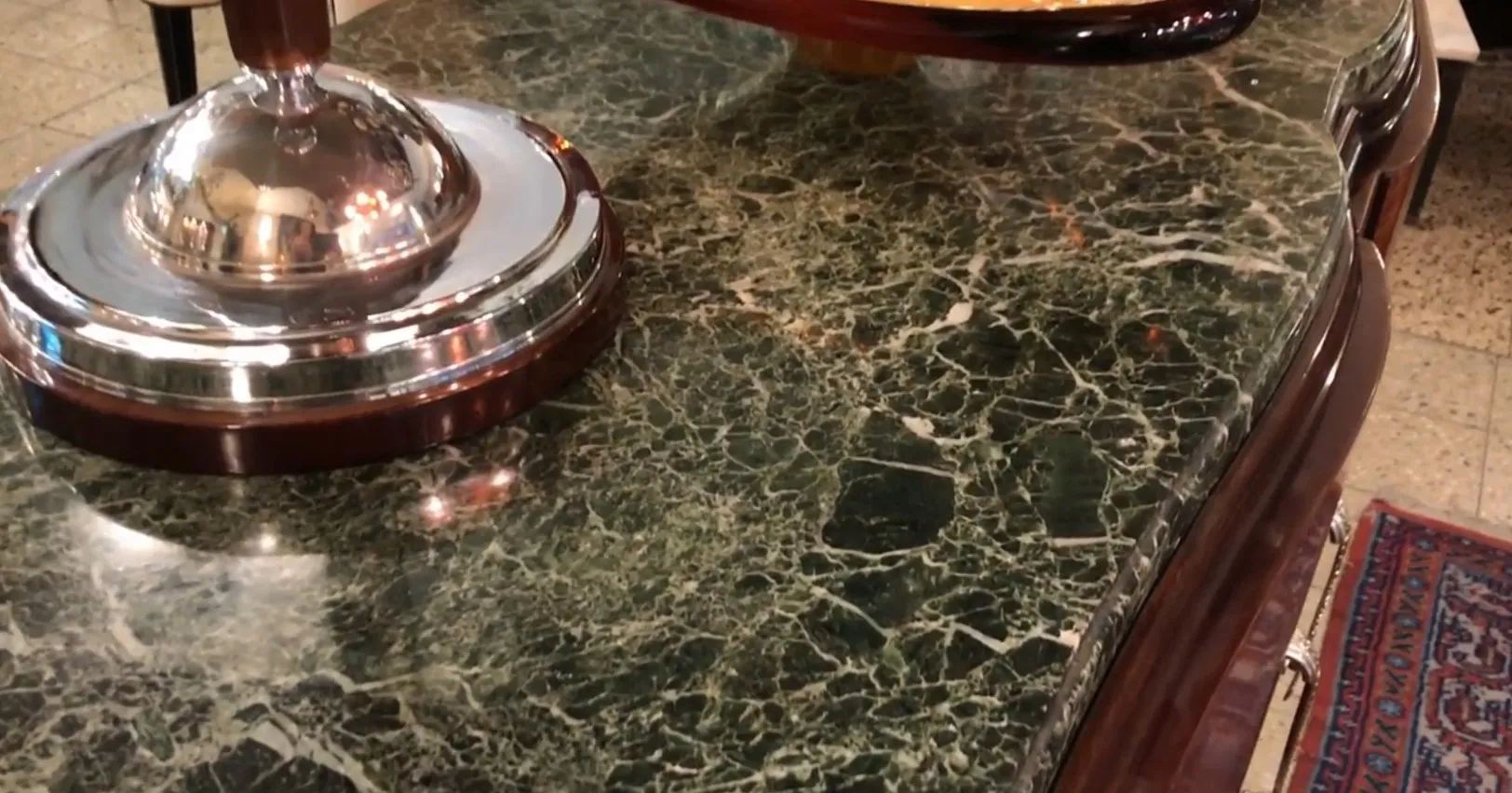 Vaisselier ancien avec surface en marbre et détails classiques. Mobilier élégant dans un cadre accueillant.