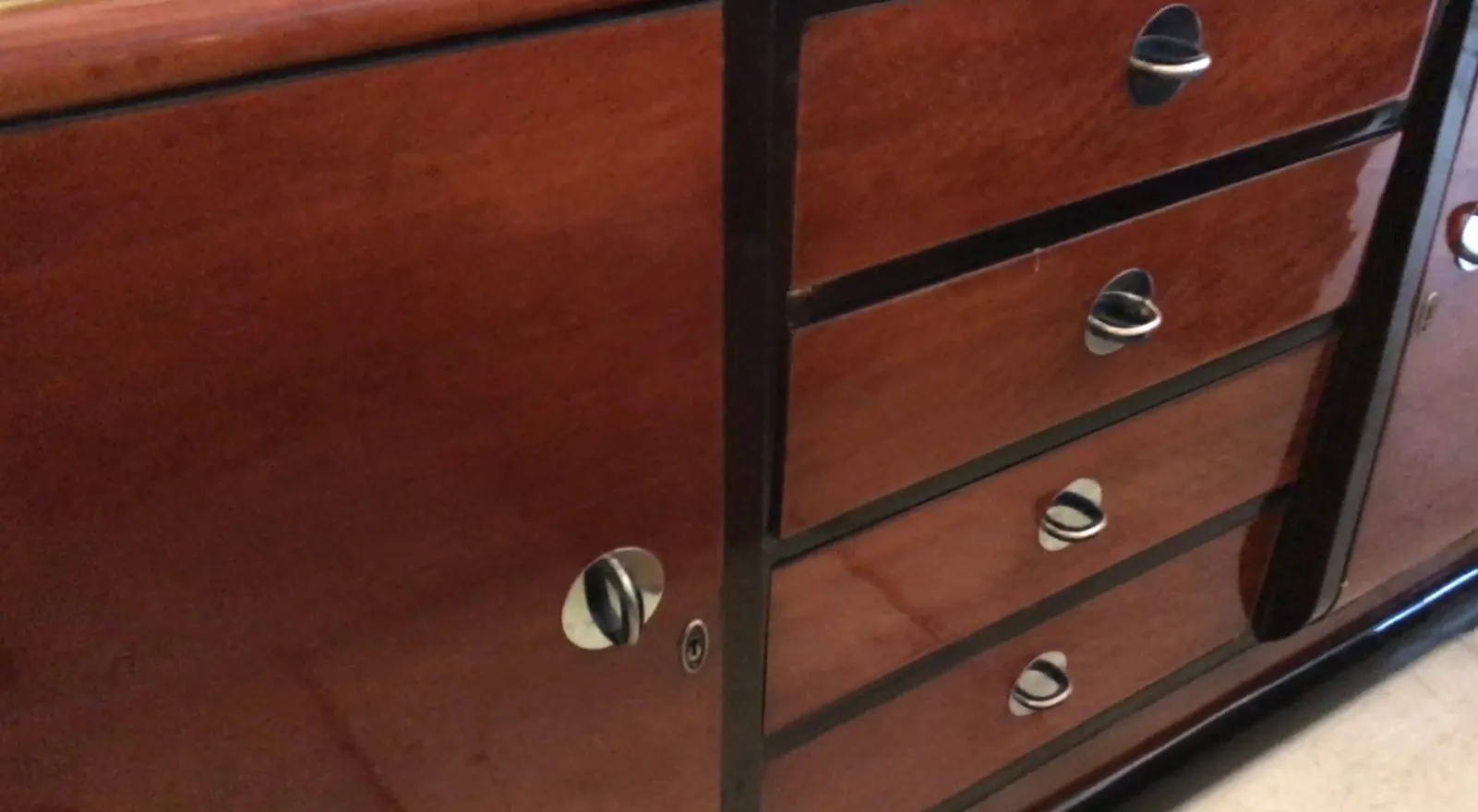 credenza antica in legno con maniglie in metallo in un contesto accogliente