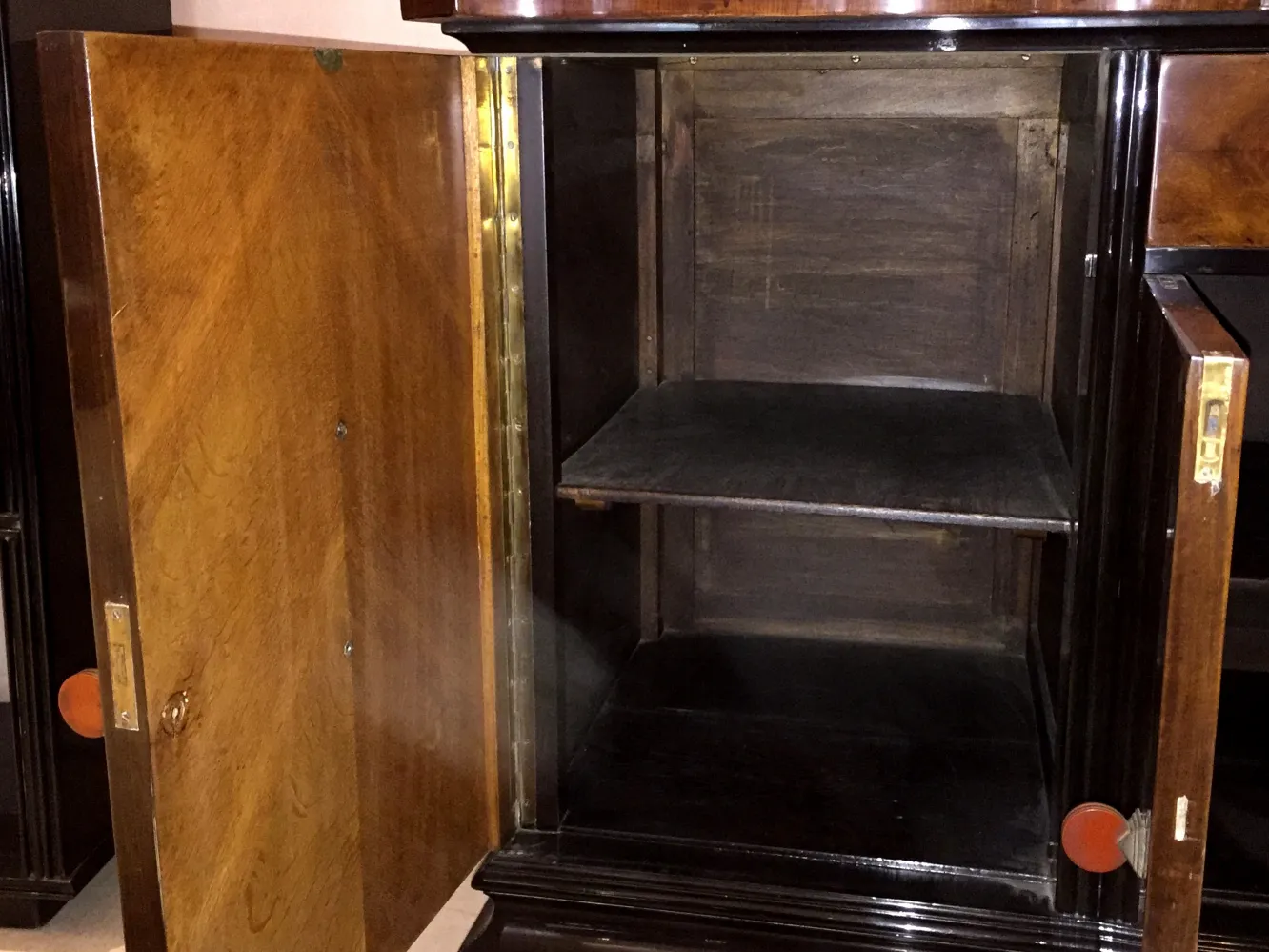 Credenza antica con porte aperte e ripiani vuoti.