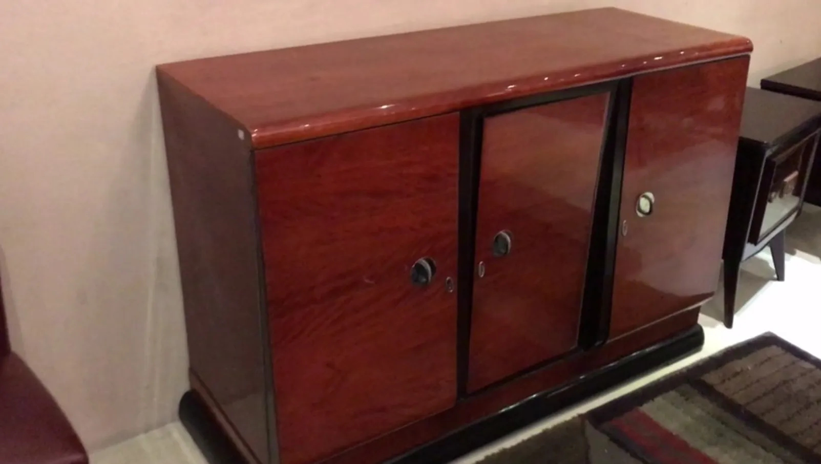 Vaisselier ancien avec des portes en verre et une finition brillante, dans un cadre confortable.