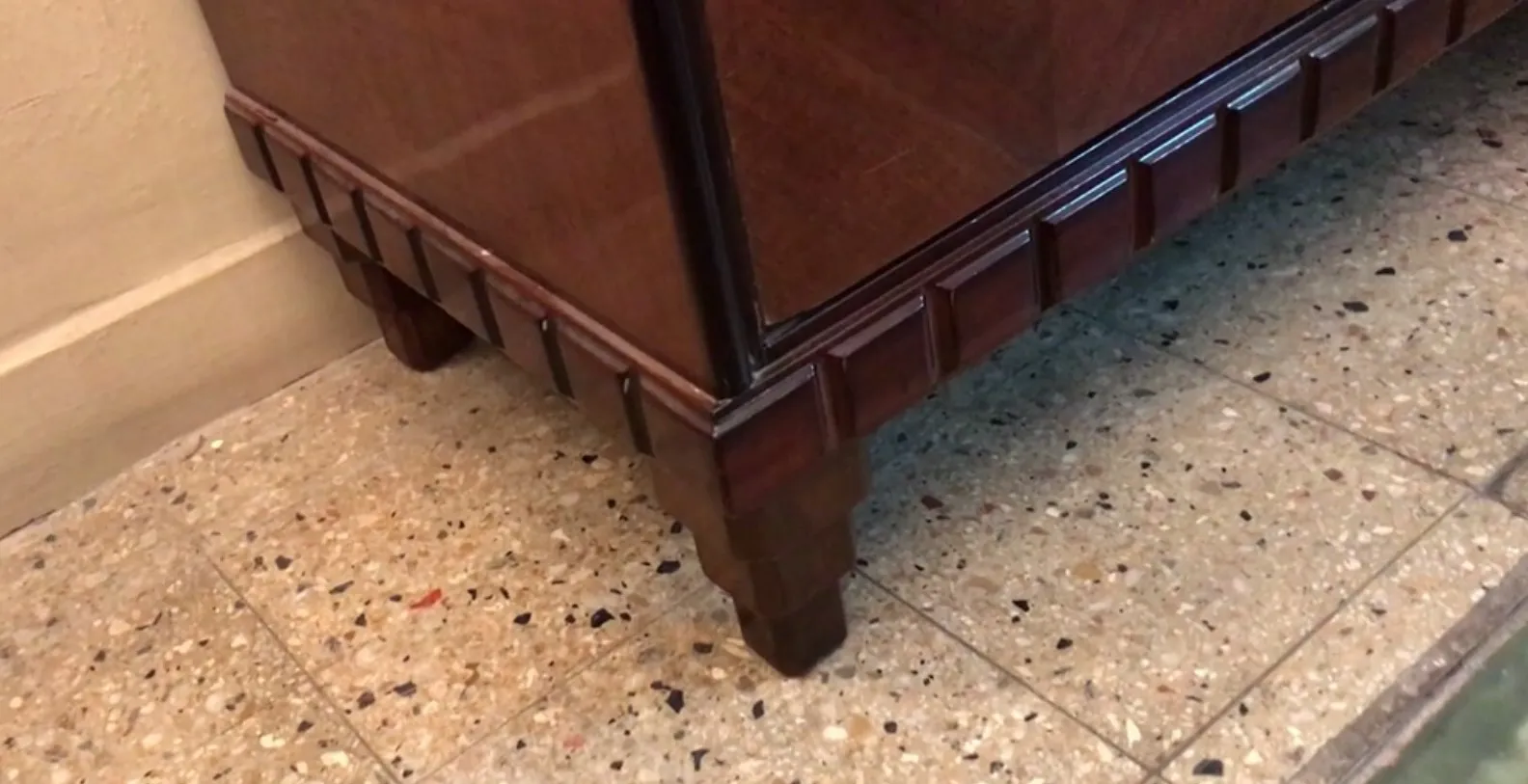 Detalles elaborados en un aparador antiguo, con patas distintivas y un ambiente clásico.