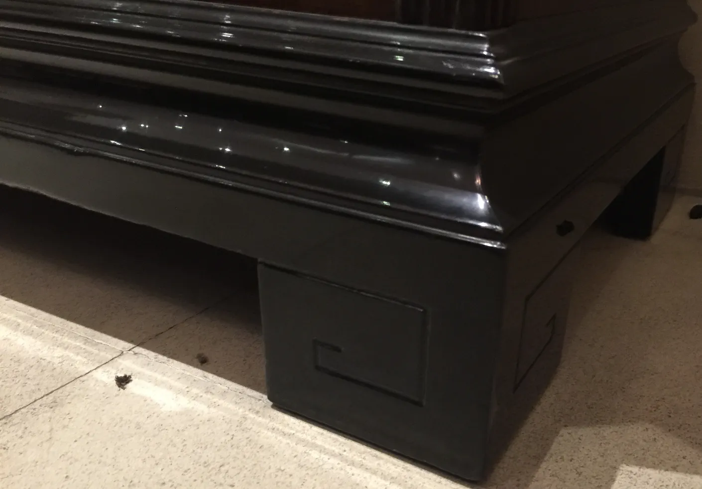 Black antique sideboard with elegant design and unique details on the edge, in a classic setting.