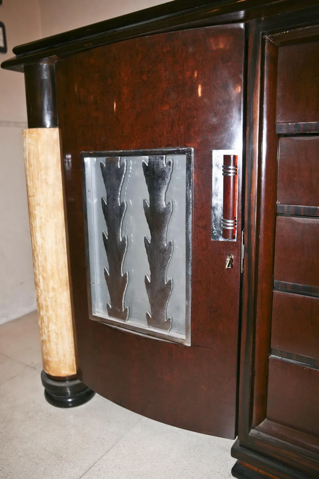 Aparador antiguo con acabados brillantes y detalles decorativos, acompañado de un ambiente clásico.