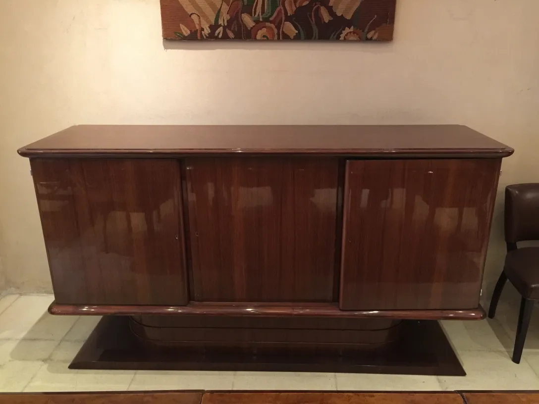 antique sideboard with glossy finishes, decorated near a painting