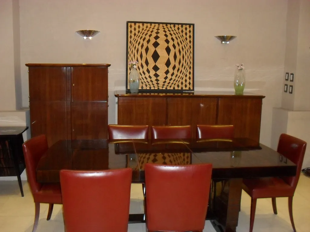 antique sideboard with a decorative backdrop and red chairs