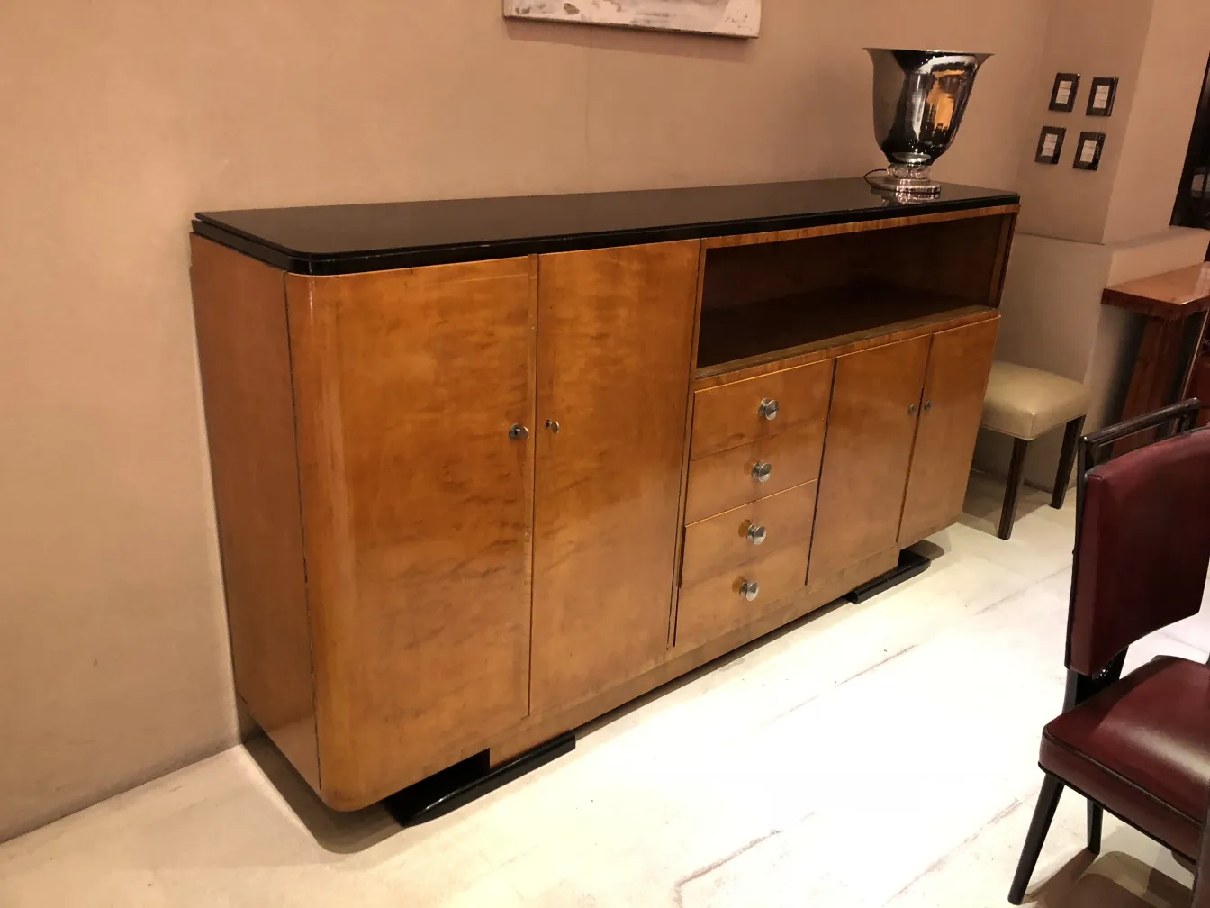 credenza antica con superfici lucide e forme eleganti, decorazione contemporanea