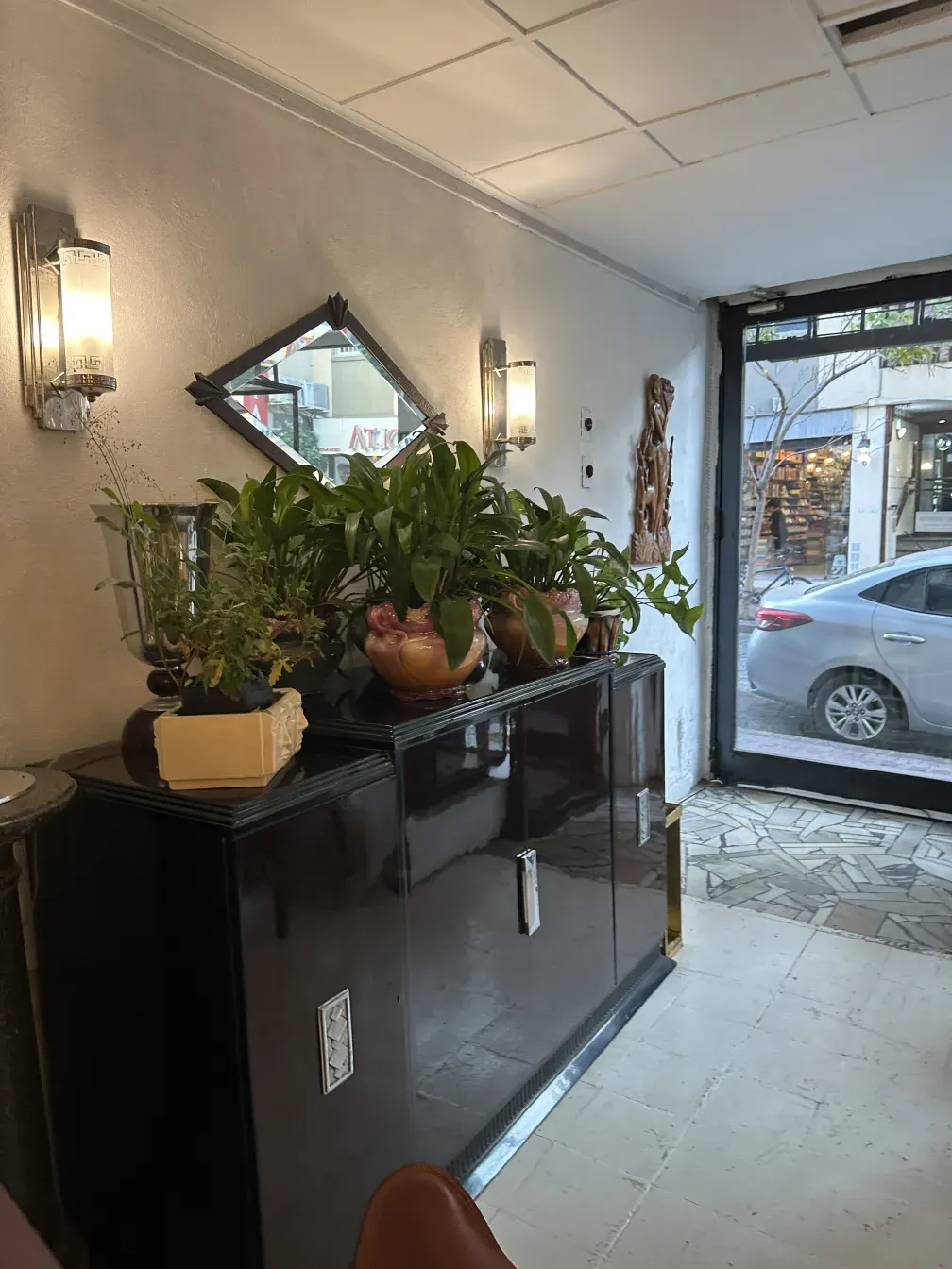 어두운 색의 고전 찬장, 식물과 거울로 장식됨