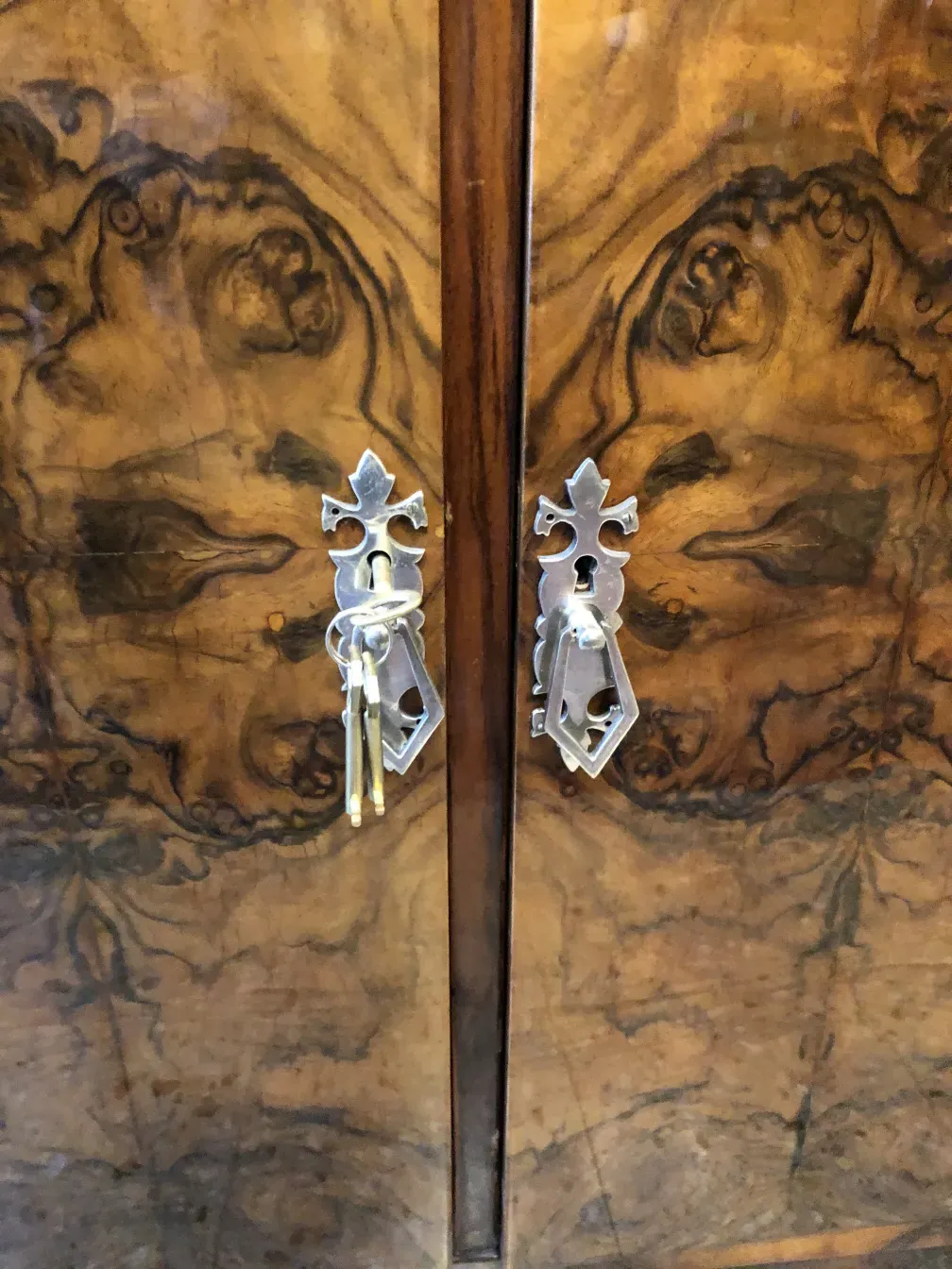 Antique sideboard with glossy finish and decorative keys.