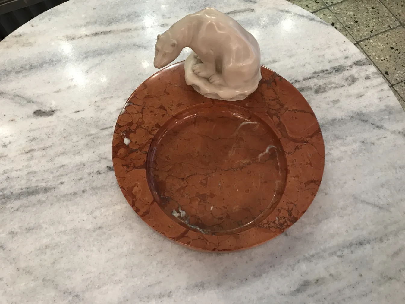 Antique standing ashtray with decorative figure on marble