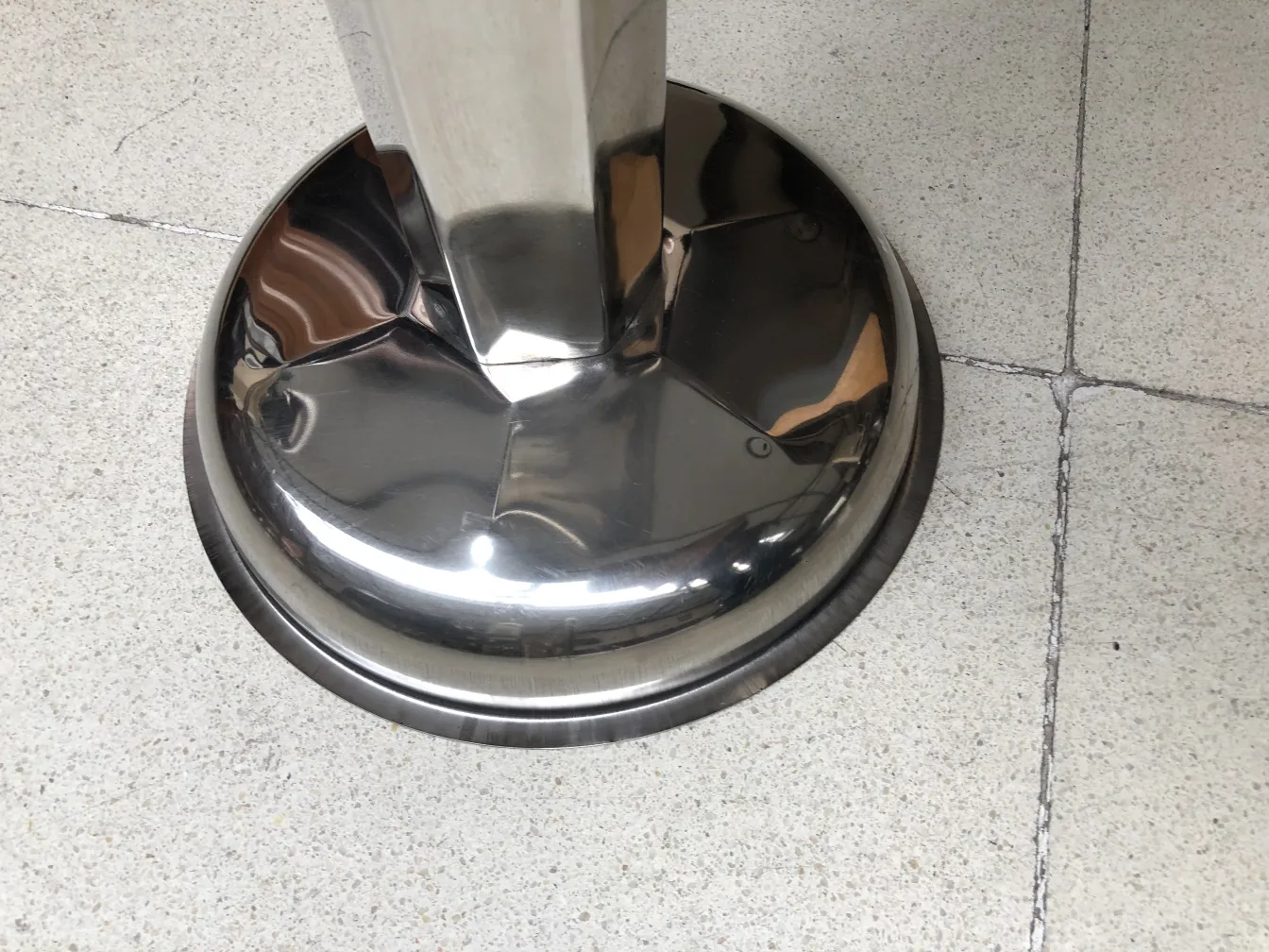 Cendrier sur pied ancien, élégant et brillant, dans un cadre neutre.