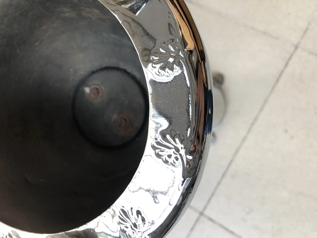 Cendrier sur pied ancien avec détails décoratifs sur fond neutre.