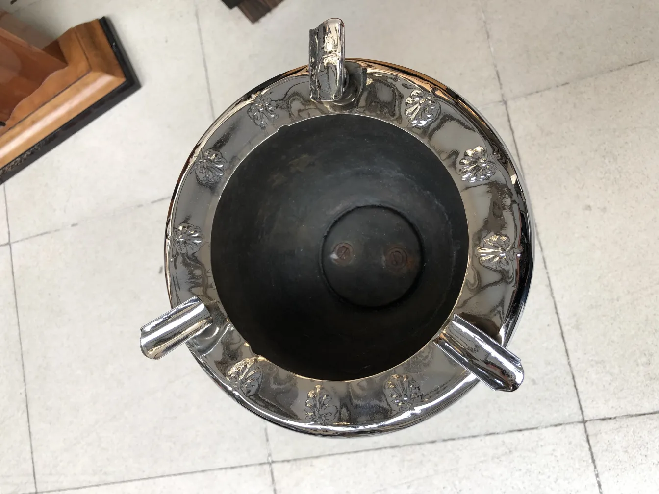Antique standing ashtray with decorative design and details.