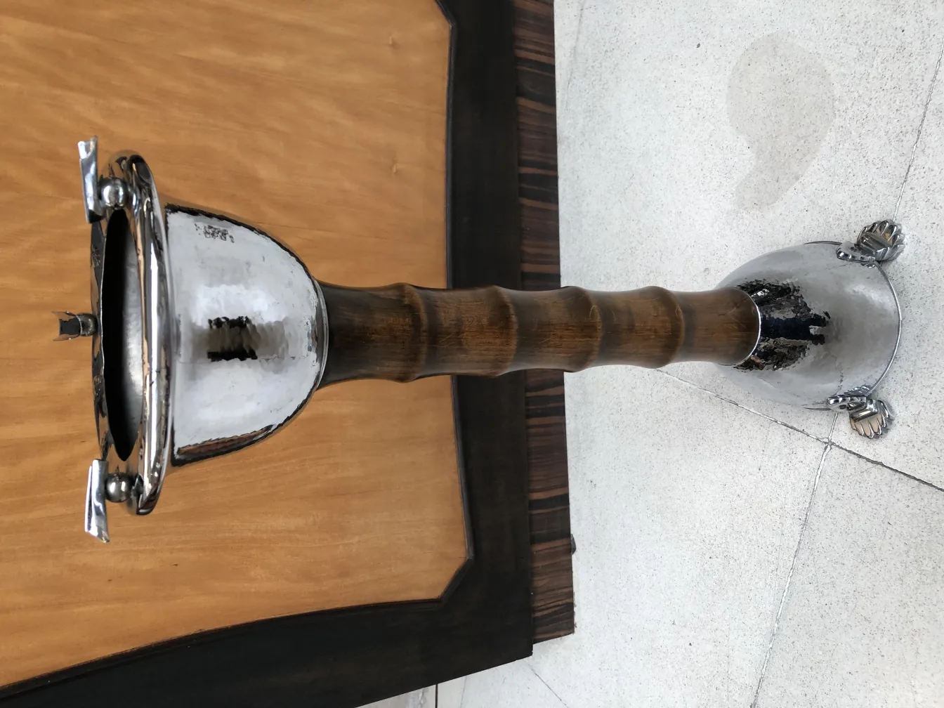 Cendrier sur pied ancien avec un design élégant, fond clair.