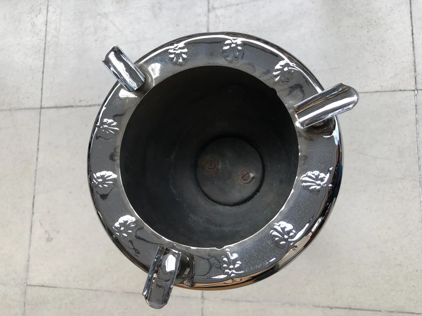 Cenicero de pie antiguo con diseño de rosas en la parte superior.