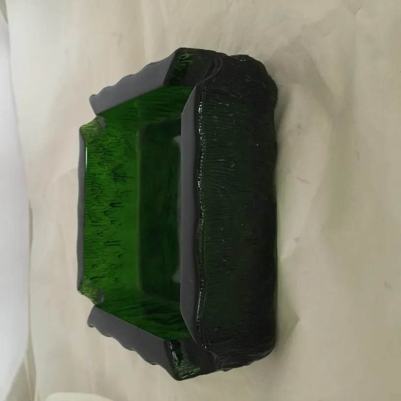 Cinzeiro de pé antigo verde com um design irregular.