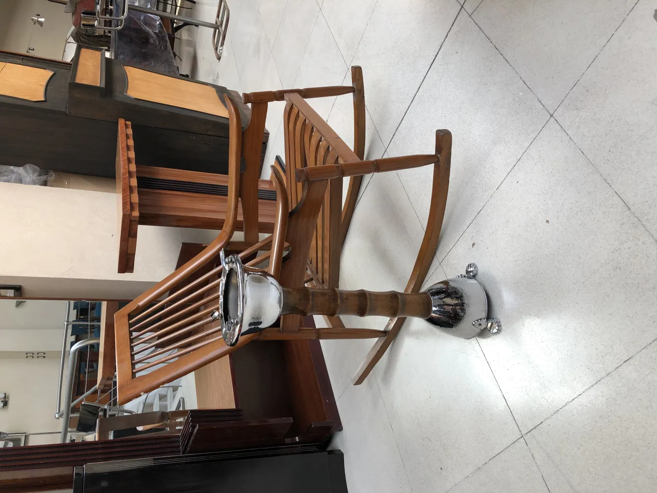 Cenicero de pie antiguo con un diseño clásico, rodeado de muebles de madera.