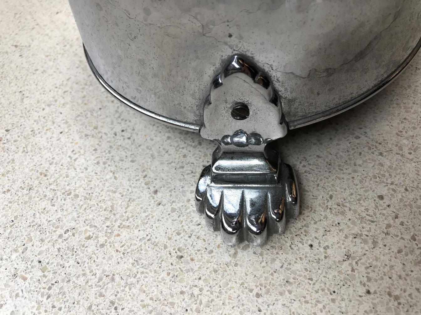 Antiker stehender Aschenbecher mit einer aufwendig gestalteten und dekorativen Basis vor neutralem Hintergrund