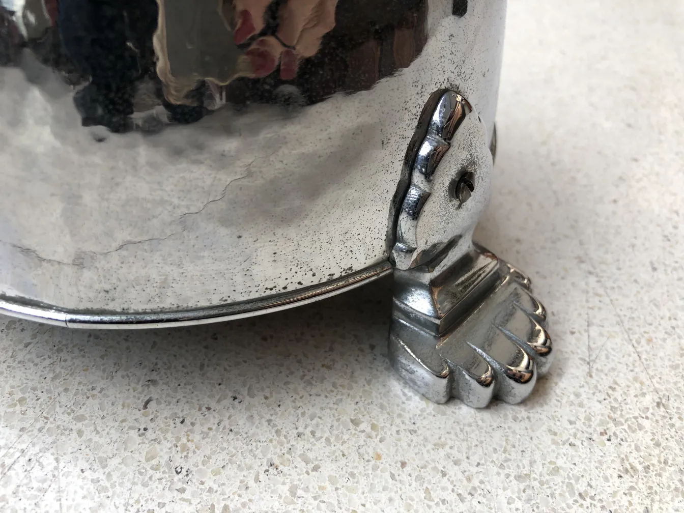 Ancien cendrier sur pied avec base en forme de pied, cadre élégant.