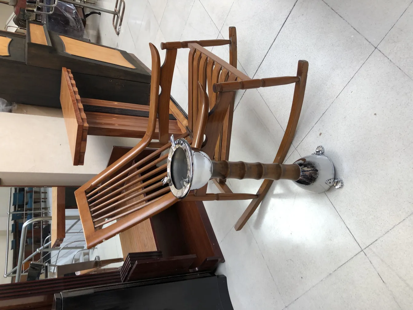 Cendrier sur pied antique avec style élégant, entouré de meubles classiques et chaleureux.