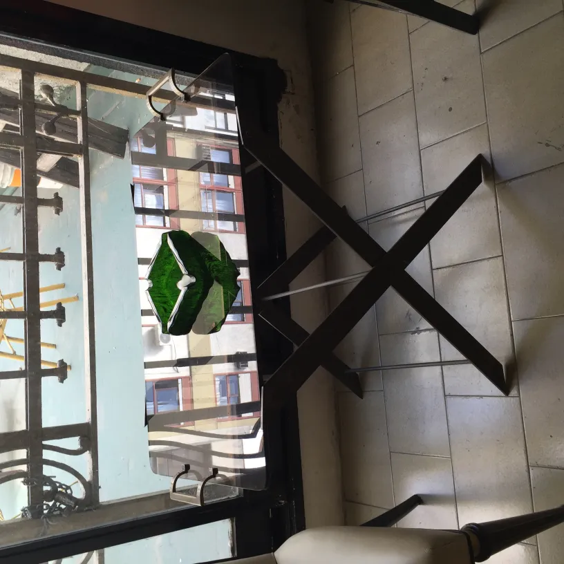 Cenicero de pie antiguo con diseño elegante, en un ambiente acogedor, junto a una ventana.