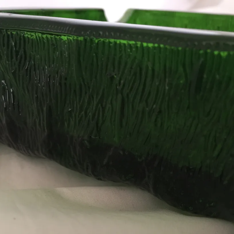 Antique standing ashtray with green glass design.