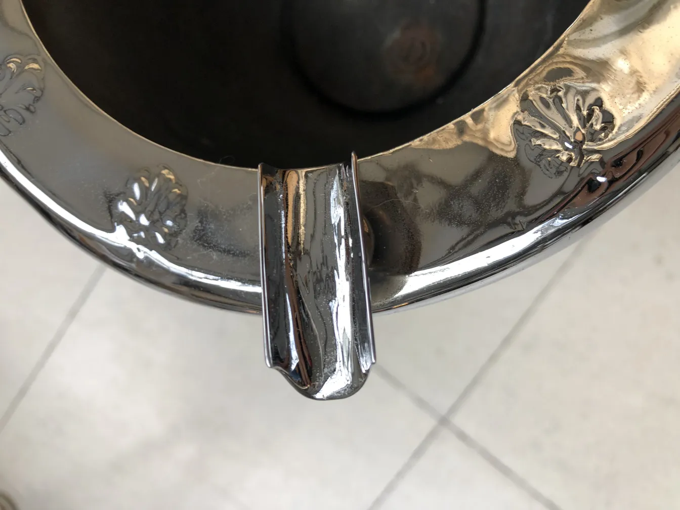 Antiker stehender Aschenbecher mit schönen dekorativen Details oben, vor einem hellen Hintergrund.