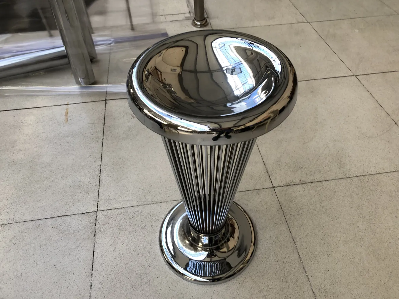 antique standing ashtray with elegant polished design by warren platner, in a modern setting.