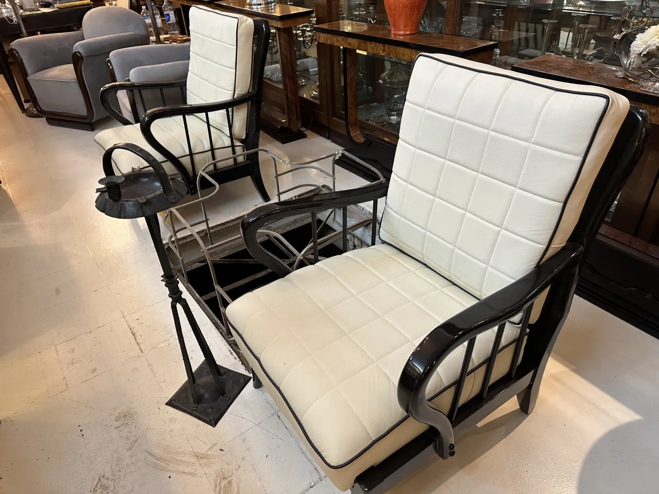 Cenicero de pie antiguo junto a sillones de estilo clásico.