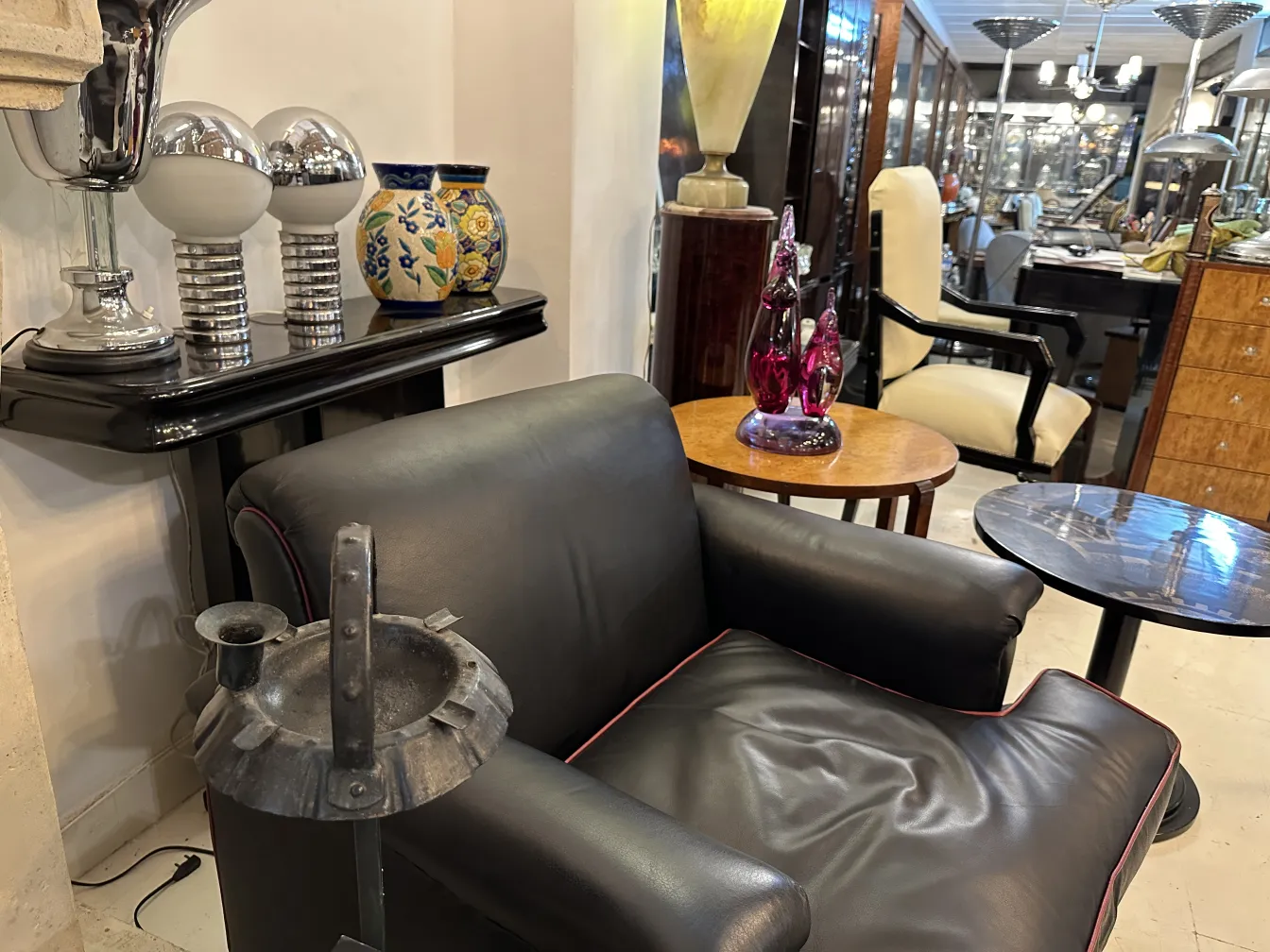 Cendrier sur pied antique dans un environnement élégant avec d'autres objets décoratifs.