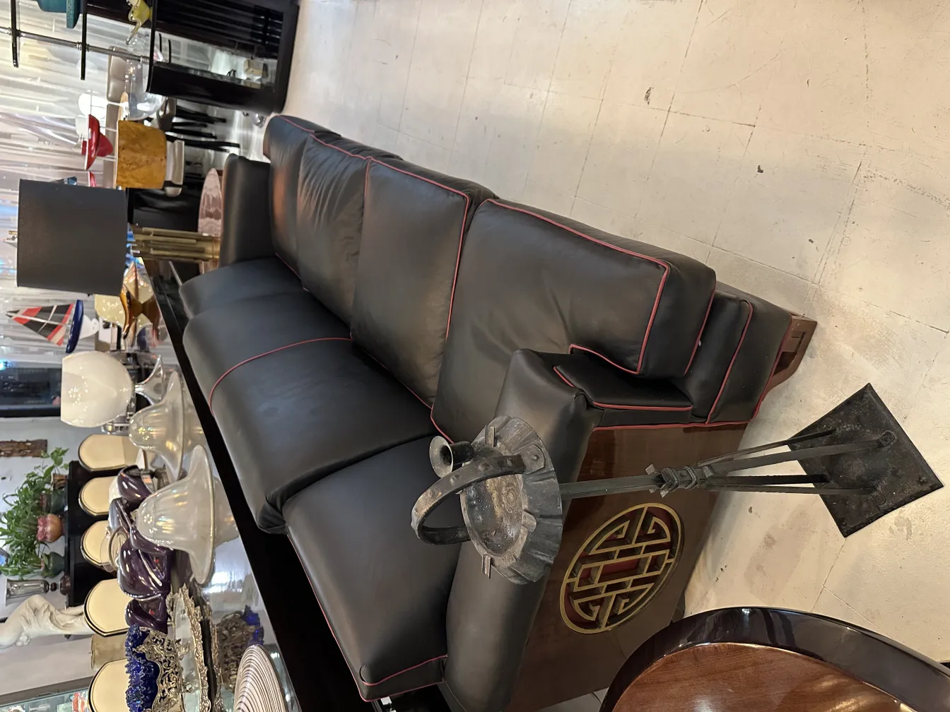 Antique standing ashtray in an elegant setting with a sofa