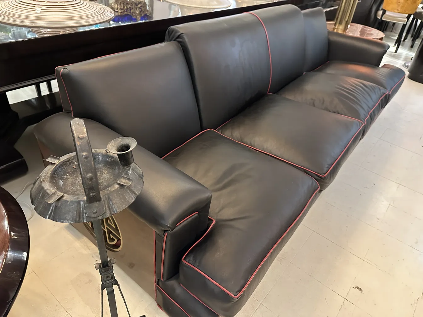 Antiker stehender Aschenbecher mit dekorativem Design neben einem Sofa