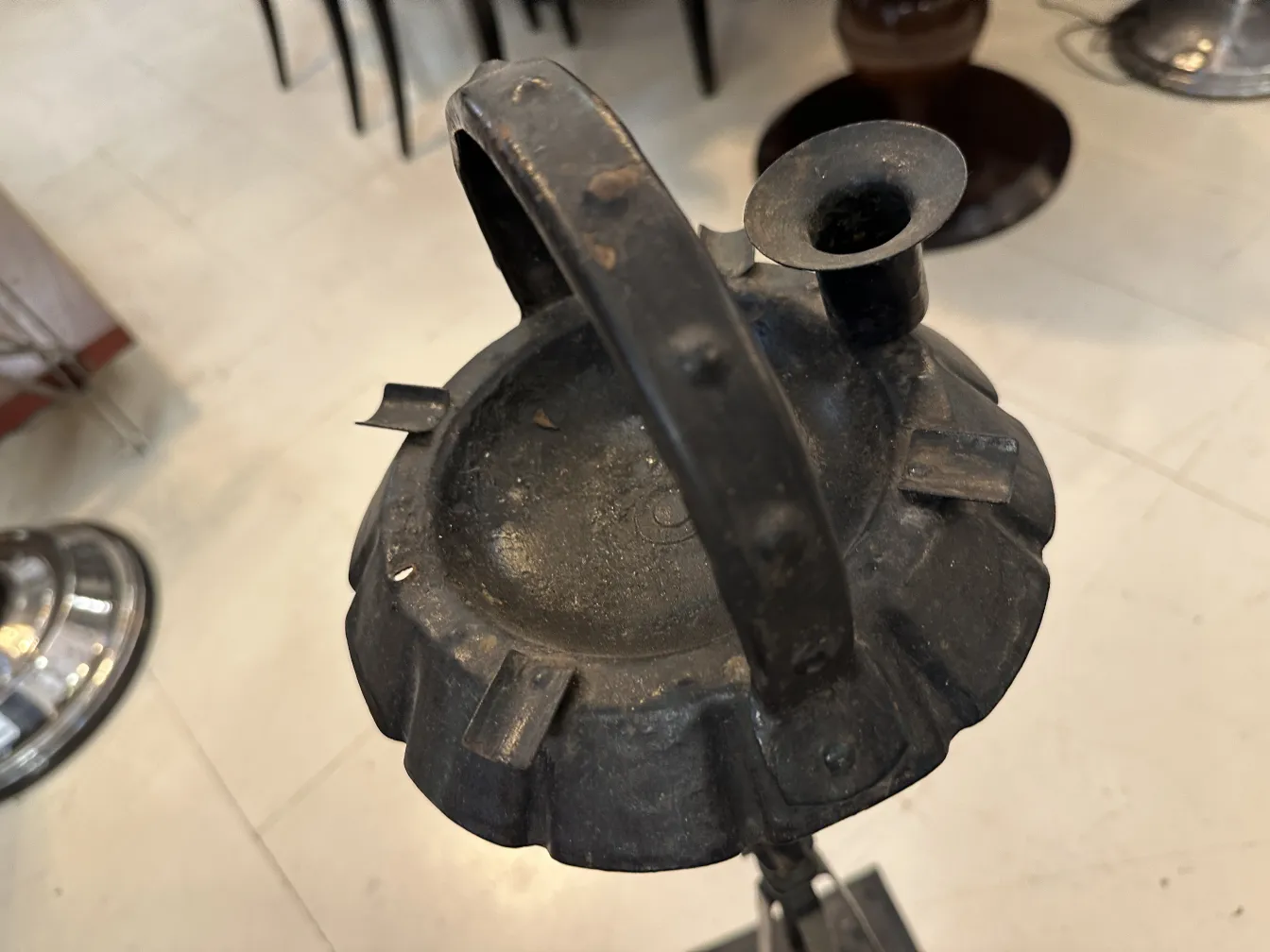 Cinzeiro de pé antigo com um design elegante, situado em um ambiente clássico.