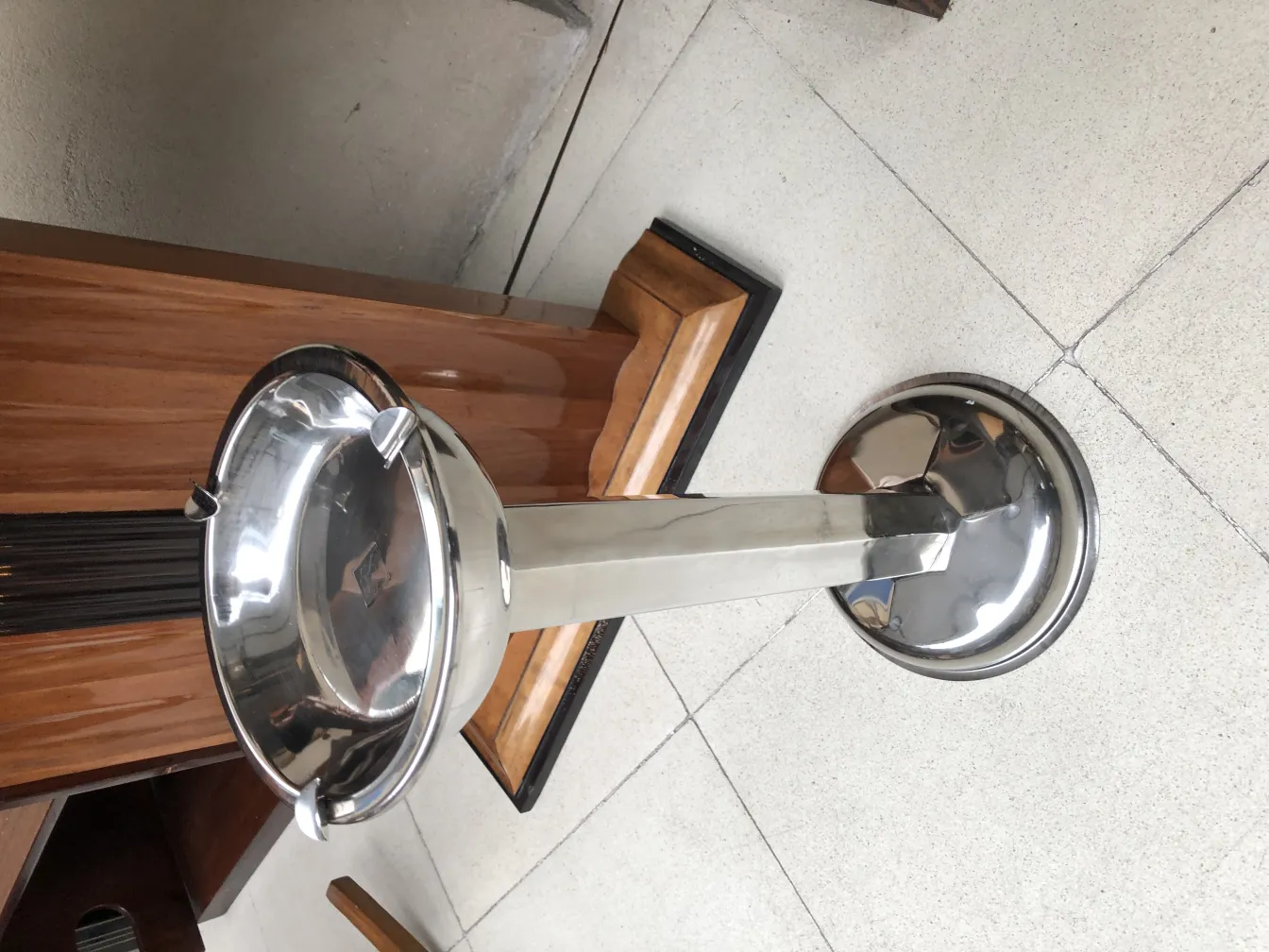 Старая стоячая пепельница, блестящая и функциональная в уютной обстановке.